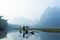 Cormorant, fish man and Li River scenery sight with fog in spring, Guilin, China