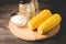 Corn. Appetizing boiled corn with salt and seasonings on a wooden table