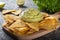 Corn chips with guacamole. A Mexican appetizer.