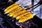 Corn cobs on the grill. Close up image with corns and hands