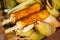 Corn cobs on the grill. Close-up image with corns and hands. Asian, Indian and Chinese street food. T