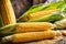 Corn cobs on a wooden table, blurred background.
