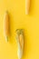 Corn on cobs on yellow background top view copyspace