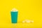 Corn curls in blue plastic cup with against yellow background with copy space. Concept of unhealthy food