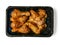 Corn fed chicken wings and drumstick in Asian style spicy marinated with herbs in a black plastic tray. Uncooked chicken meat