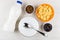 Corn flakes, raisin, prunes, yogurt, bowl with spoon on table