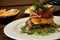 Corn fritter with bacon, halloumi and spinach in white plate serve on wood table. Fresh cook corn fritter on wood table with cafe