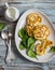 Corn fritters and fresh spinach on a wooden background. Vegetarian Breakfast or snack