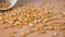 Corn grains are poured from a bowl onto a board from a white bowl