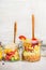 Corn and lentil salads in glass jars on white wooden background.