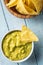 Corn nacho chips and avocado dip. Yellow tortilla chips and guacamole