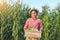 Corn planter holds a wooden crate that is full of corn pods with a smiling face