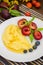 Corn porridge with honey, plum, blueberry and cherry-rogue. Wooden background. Top view. Close-up