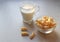 Corn sticks with a glass of milk on a light background, side view-the concept of quick healthy snacks