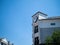 Corner of contemporary building with clock tower at 2 oclock in afternoon