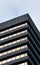 corner detail of a typical brutalist style 1960s concrete office building with geometric concrete framework against a grey