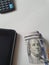 corner of an electronic tablet, American dollar money and calculator on the table