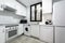 Corner of a fully fitted white kitchen with matching white appliances