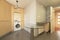 Corner of a kitchen with column cabinets in beech wood color and circular glass side table