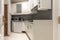 corner of a kitchen with white wooden cabinets, a glass cabinet,