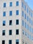 Corner of minimal building facade with simple glass windows. Vertical photo