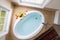 Corner oval bathtub full of clean water