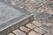 Corner of a pedestrian sidewalk made of granite curb.