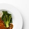 Corner of a plate of Asparagus and Broccoli on a white plate.