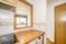 Corner of a small apartment kitchen with a hatch window to the living room