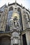 Corner, with statues and golden element with rays, two windows and sky in Vienna.