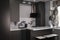 Corner of stylish Minimalistic grey kitchen, dark gray cupboards, white countertops and bar with stools. black sink, kettle and