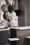 Corner of stylish Minimalistic grey kitchen, dark gray cupboards, white countertops and bar with stools. black and white balloons