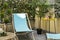 Corner of an urban terrace with wooden hammocks and blue fabric, artificial decorative plants and stone floors