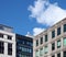 Corner view of a group of modern office buildings against a blue sky with clouds