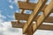 Corner of a wooden pergola against blue sky