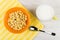 Cornflakes in bowl, spoon on napkin, milk, spoon on table