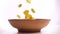 Cornflakes falling in the bowl on white background, slow motion