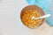 Cornflakes in a metal bowl with milk on a painted white wooden background. Composition with a dish towel and spoon.