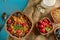 Cornflakes and other cereals with fresh fruits of raspberries, blueberries and milk