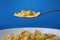 Cornflakes in spoon over blue background