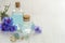 Cornflower flower blue water in glass bottles and bath salt on white wooden table background. Essential oil of knapweed for