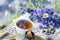 Cornflower herbal tea in white cup on white crochet napkin on wooden table, healthy cornflower drink with honey