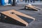 Cornhole game set, process of throwing bean bags, kids children tossing bean sacks, corn hole in the backyard, wooden boards for