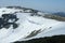 Cornices of snow on top of a snowy and sunny mountain