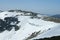 Cornices of snow on top of a snowy and sunny mountain