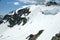 Cornices of snow on top of a snowy and sunny mountain