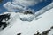 Cornices of snow on top of a snowy and sunny mountain