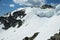 Cornices of snow on top of a snowy and sunny mountain