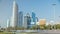 Corniche boulevard beach park along the coastline in Abu Dhabi with skyscrapers on background.