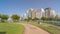 Corniche boulevard beach park along the coastline in Abu Dhabi with skyscrapers on background.